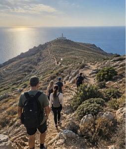 Μικρή ομάδα πεζοπόρων στο μονοπάτι προς το Ακρωτήρι Ταίναρο, με θέα τη θάλασσα και τον φάρο